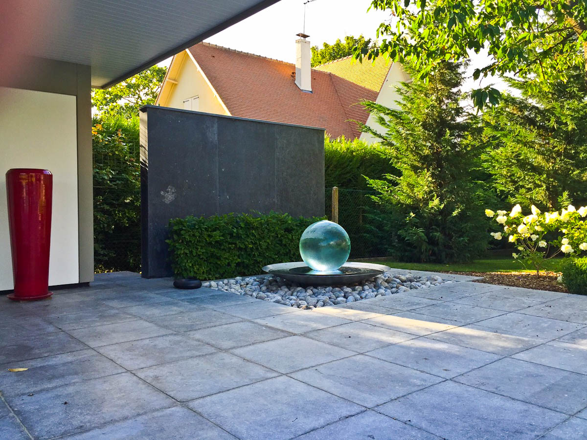 Fountain in garden near wall in shade
